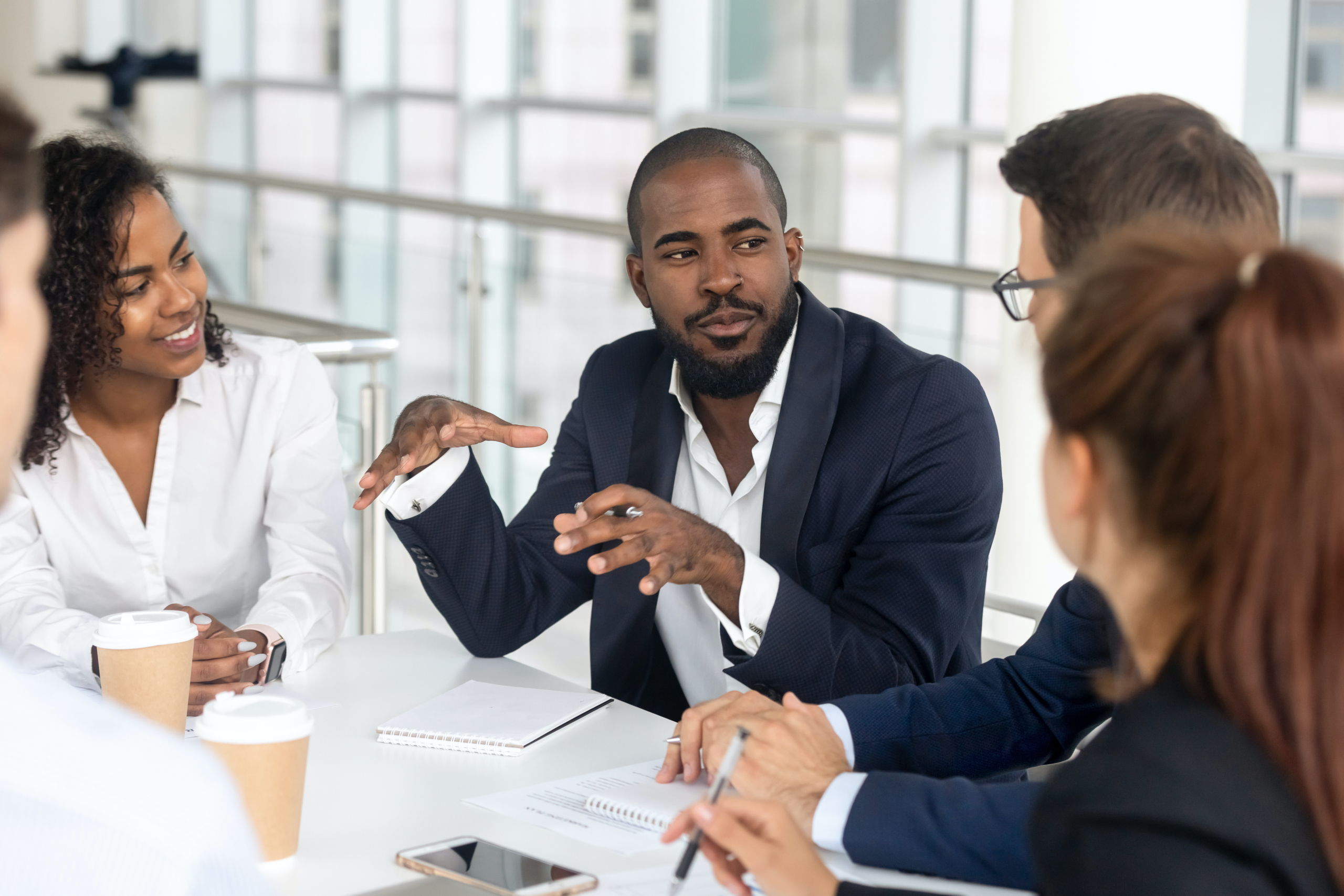 A group of people gathered in a boardroom for a business meeting .